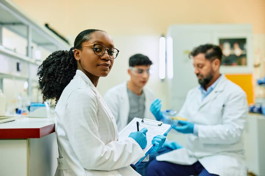 black-female-scientist-writing-notes-during-a-rese-2023-11-27-04-57-36-utc