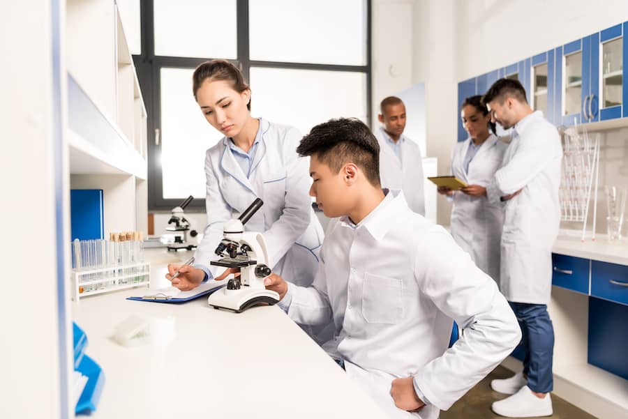 young-lab-technicians-working-with-microscope-and-2023-11-27-05-05-06-utc